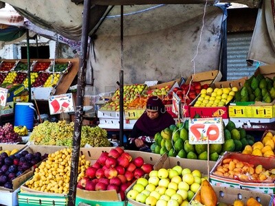 Egyptian woman sits at a small fruit stand in Egypt​