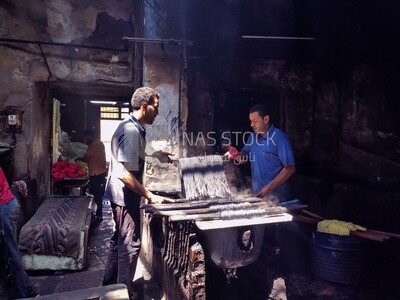 Two men working in the profession of dyeing threads