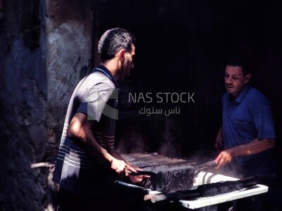 Two men dye threads black in an ancient dyeing workshop in Egypt