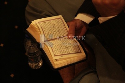 رجل يحمل المصحف بيده ، يقرأ القرآن الكريم ، الإسلام والعبادة ، تلاوة القرآن وحفظه ، مسجد