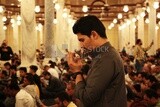 Side view of a man in the mosque, praying to God, praying on the prayer rug, performing the obligatory prayer in the mosque, worship and draw close to God