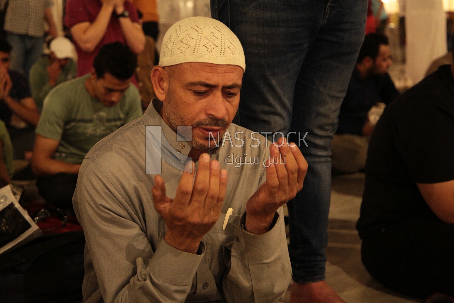 Man sitting in the mosque, praying to God, praying on the prayer rug, performing the obligatory prayer in the mosque, worship and draw close to God
