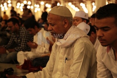 Worshipers praying in a mosque, performing the obligatory prayer in the mosque, worship and draw close to God