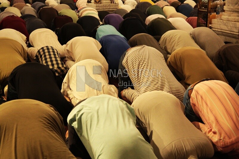 Worshipers praying in a mosque, performing the obligatory prayer in the mosque, worship and draw close to God