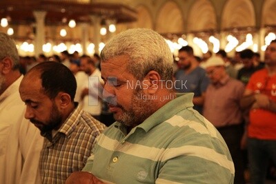 Worshipers praying in a mosque, performing the obligatory prayer in the mosque, worship and draw close to God