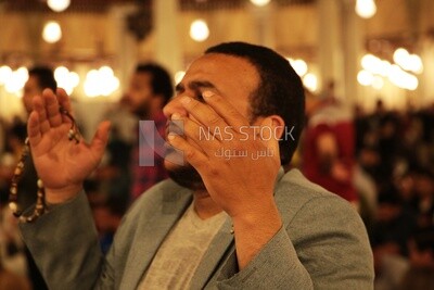 رجل جالس في المسجد ، يصلي إلى الله ، يصلي على السجادة ، ويؤدي صلاة الفريضة في المسجد ، ويصلي ويقترب من الله