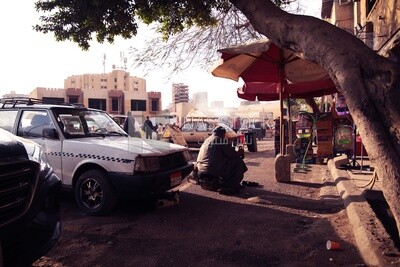 Man sitting on the street cleaning shoes polishing shoes