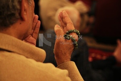 Man sitting in the mosque, praying to God, praying on the prayer rug, performing the obligatory prayer in the mosque, worship and draw close to God