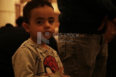 Boy in the mosque during the worshipers praying, performing the obligatory prayer in the mosque, worship and draw close to God