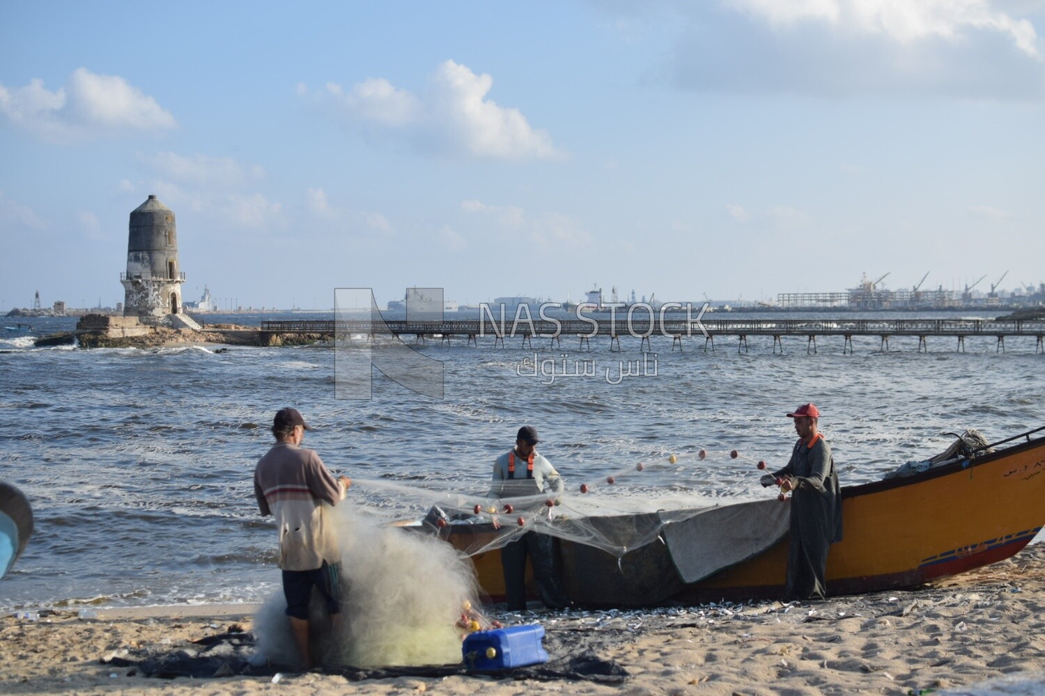 Egyptian fishermen collect fish after fishing near the El-Max Lighthouse in the Alexandria Sea ,Egypt