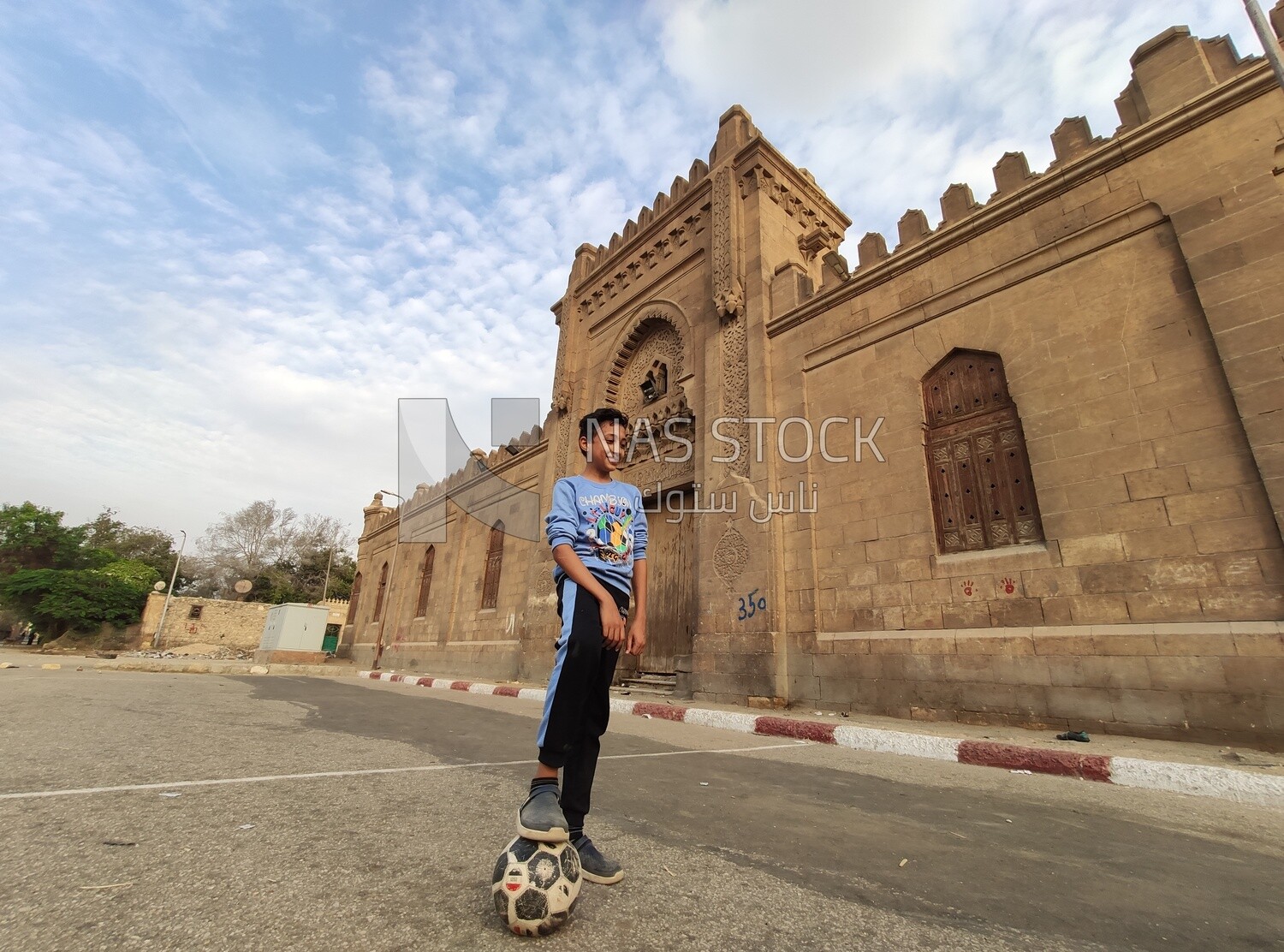 Egyptian child plays ball in the square in front of a cemetery in a city called &quot;City of the Dead&quot; in Egypt