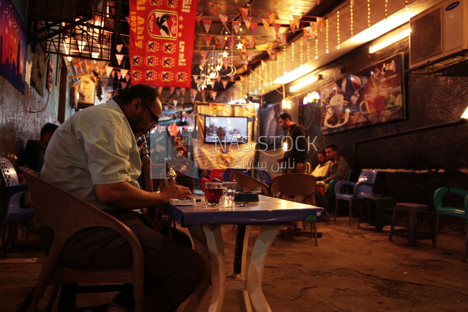 People sitting in a street coffee shop, Ramadan