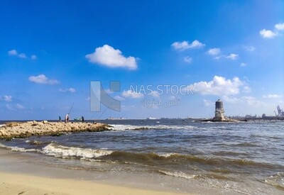 Group of men enjoy fishing near the El Max lighthouse in the Alexandria Sea