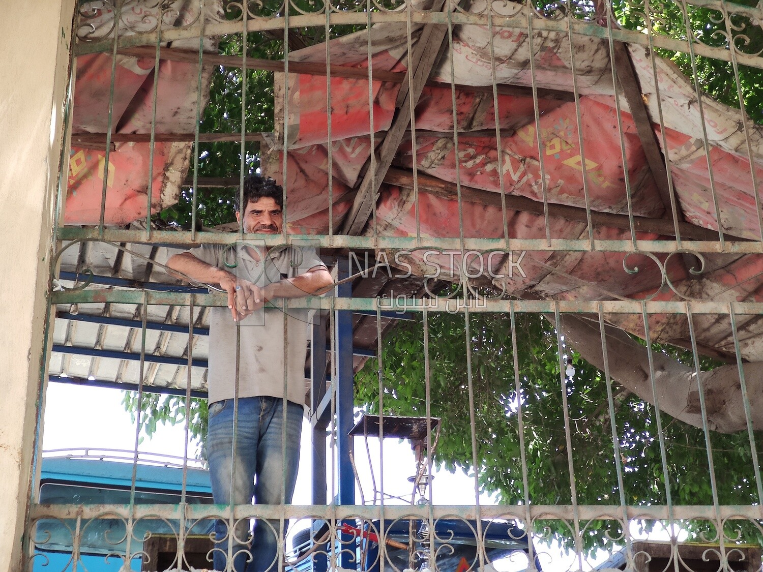 Egyptian man stands behind iron bars