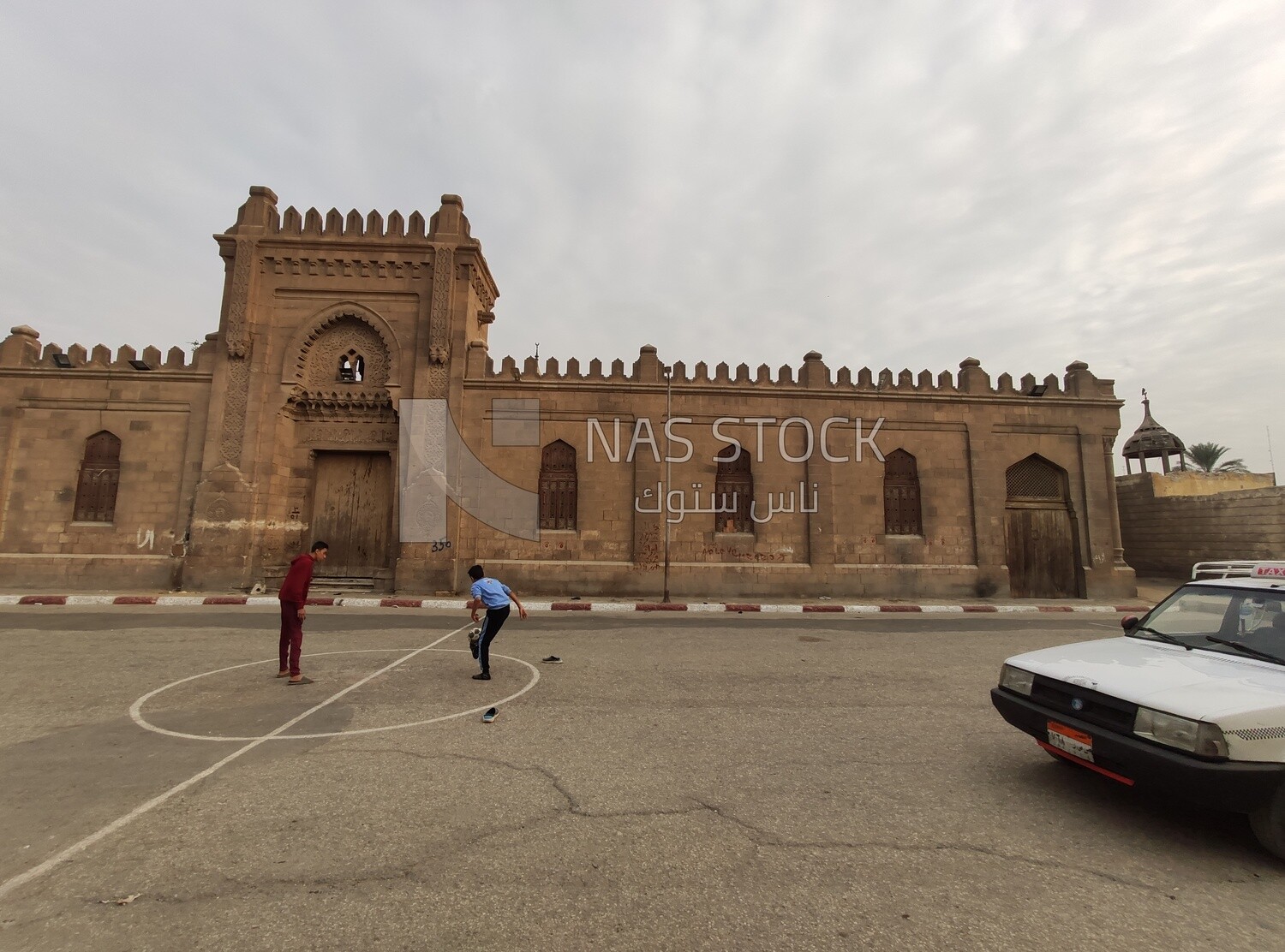 Egyptian child plays ball in the square in front of a cemetery in a city called &quot;City of the Dead&quot; in Egypt