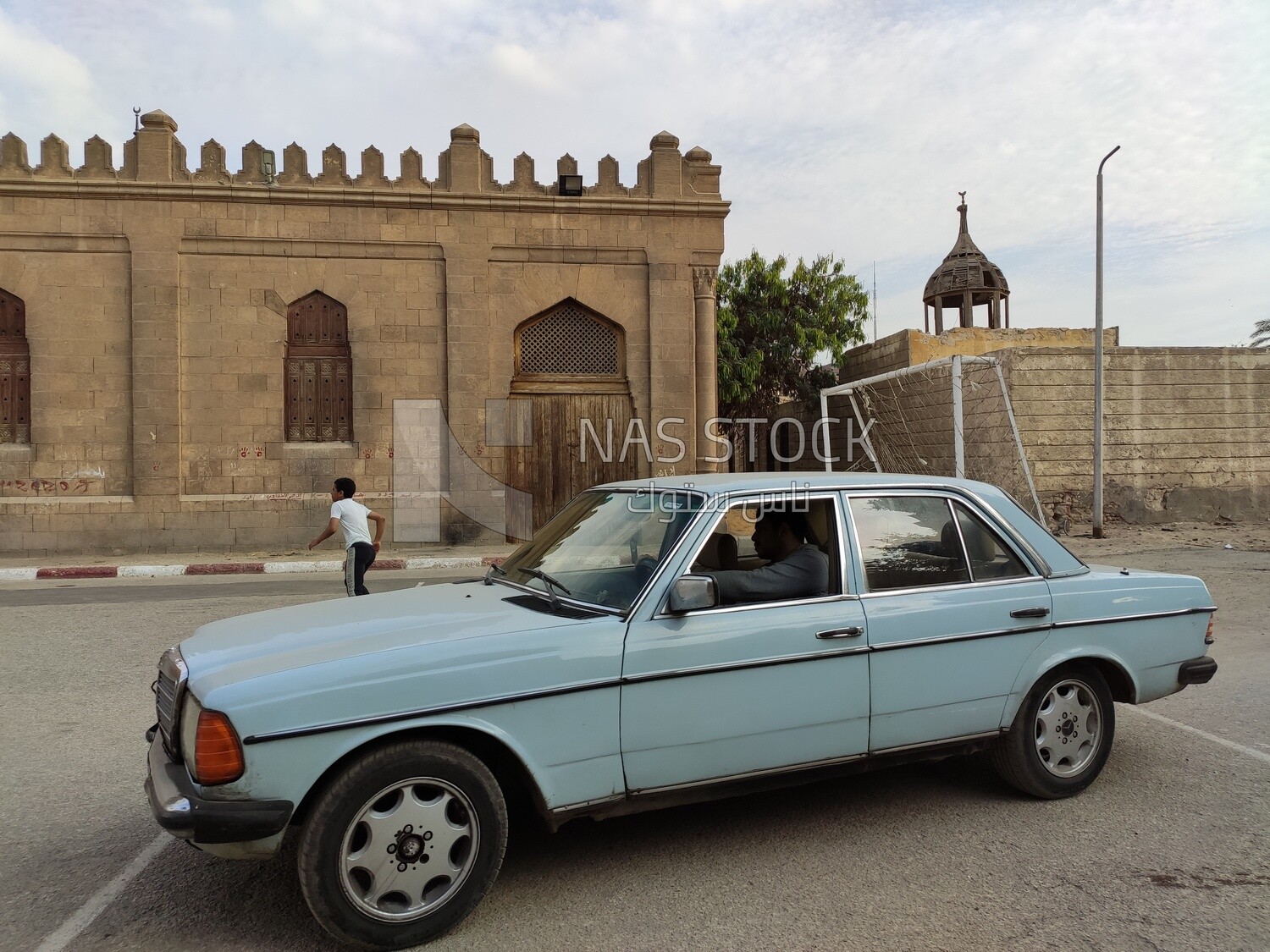 Old-fashioned car from the cars of the last century driven by a man in the streets of Cairo