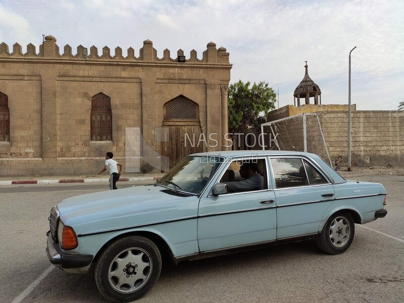 Old-fashioned car from the cars of the last century driven by a man in the streets of Cairo