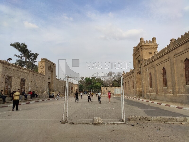 Children playing soccer in front of a tomb in a city called "City of the Dead" in Cairo, Egypt