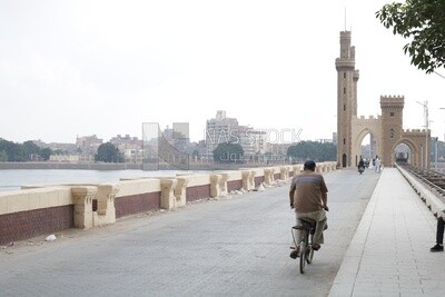 Man crosses a bridge on his bike