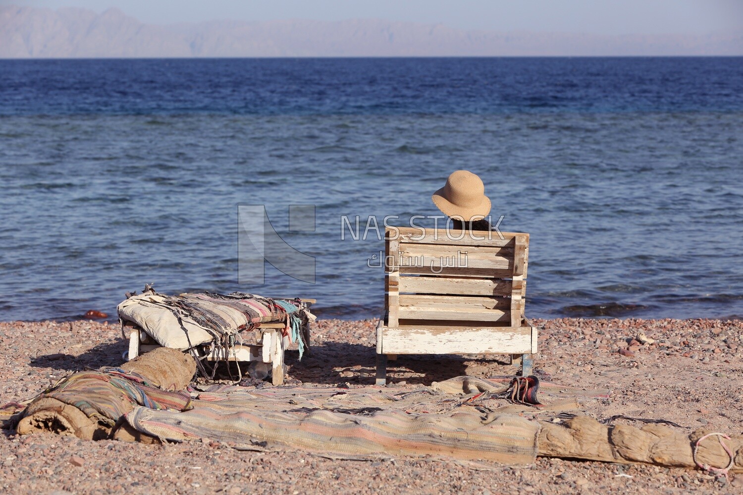 Girl sitting in harmony in front of the sea enjoying the natural view