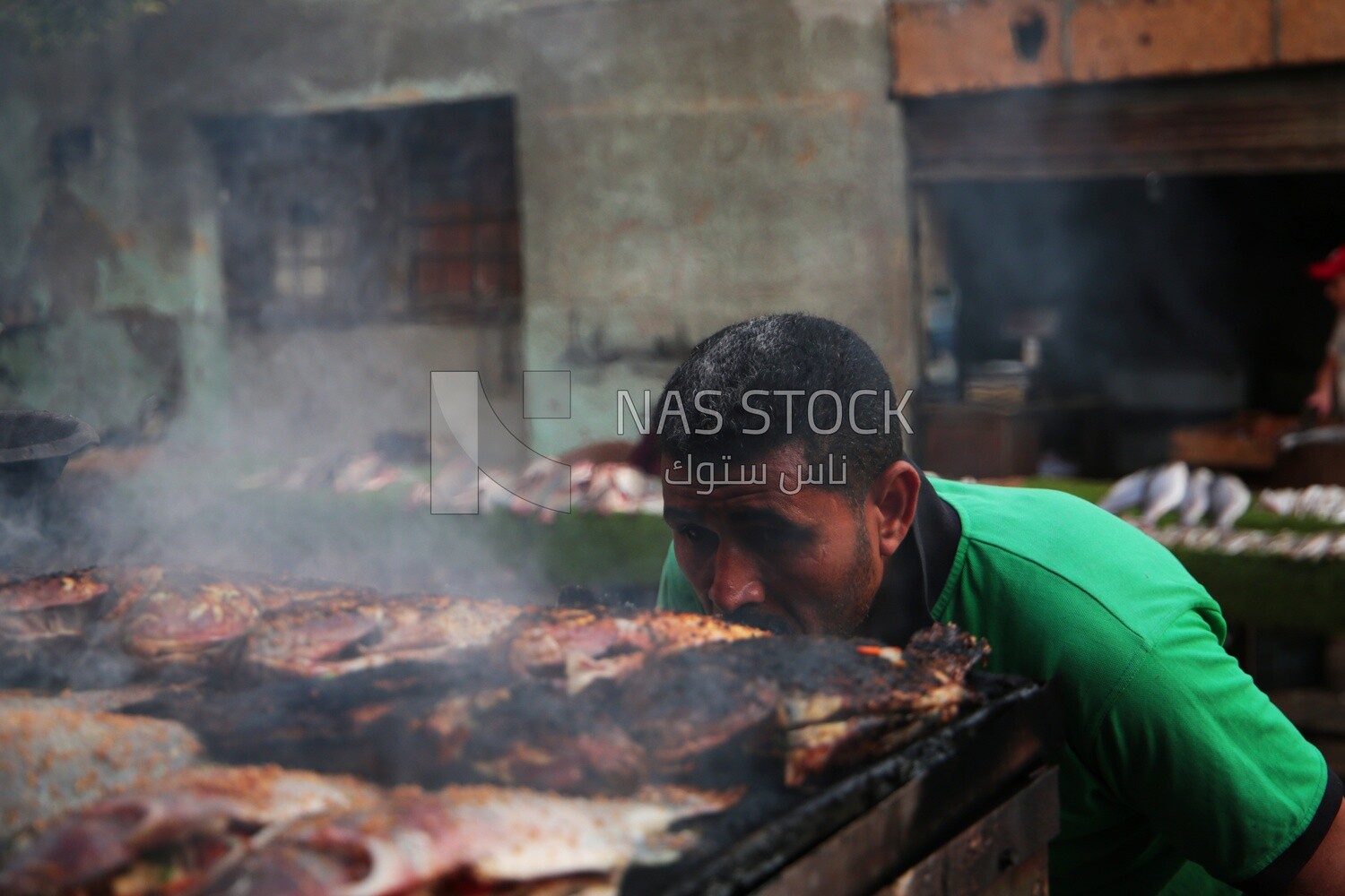 Man grilling fish, street food, Ramadan Kareem