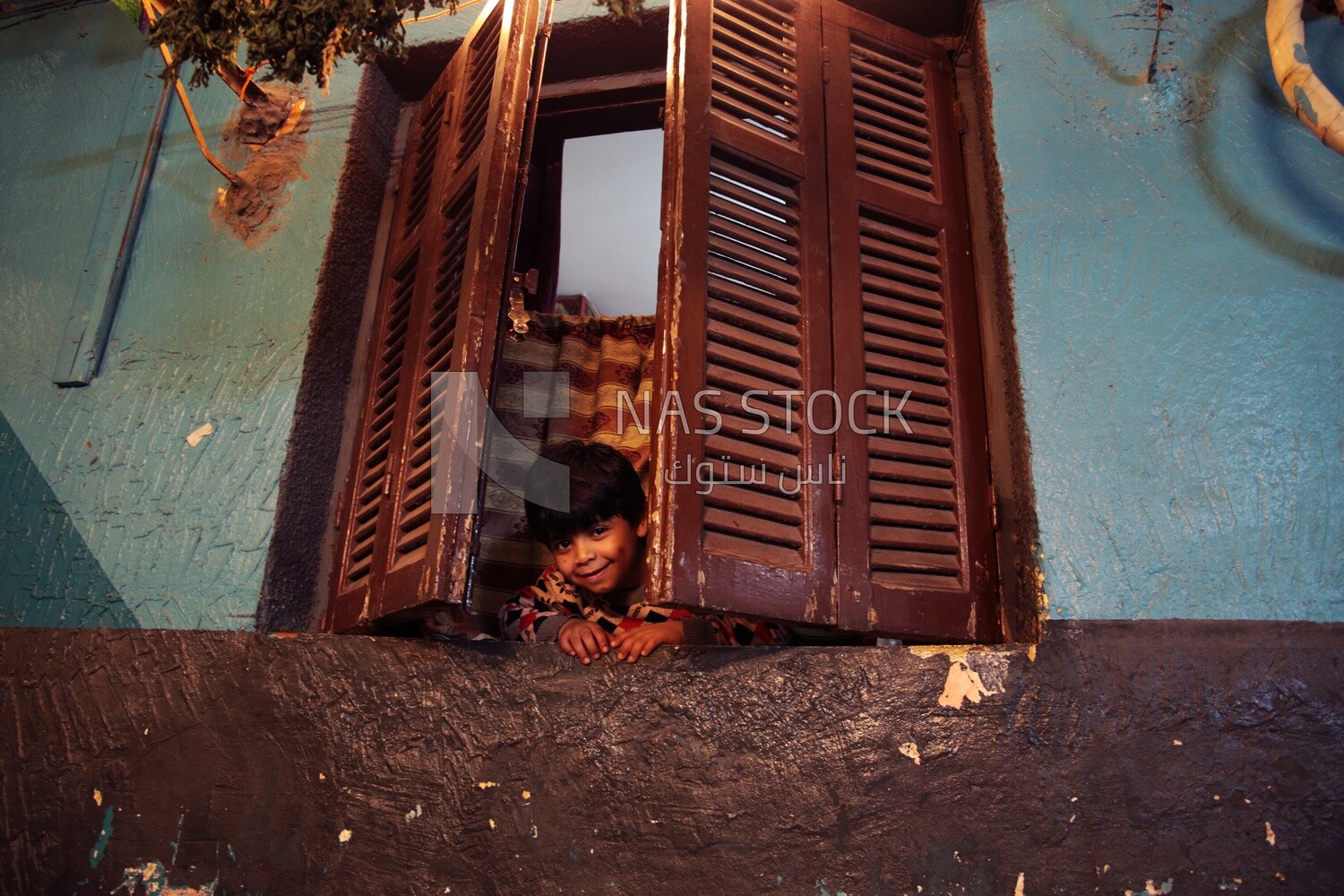 Boy looking from the window, old building
