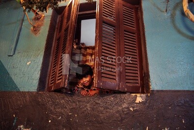 Boy looking from the window, old building