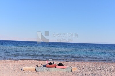 Two girls enjoying lying in front of the sea