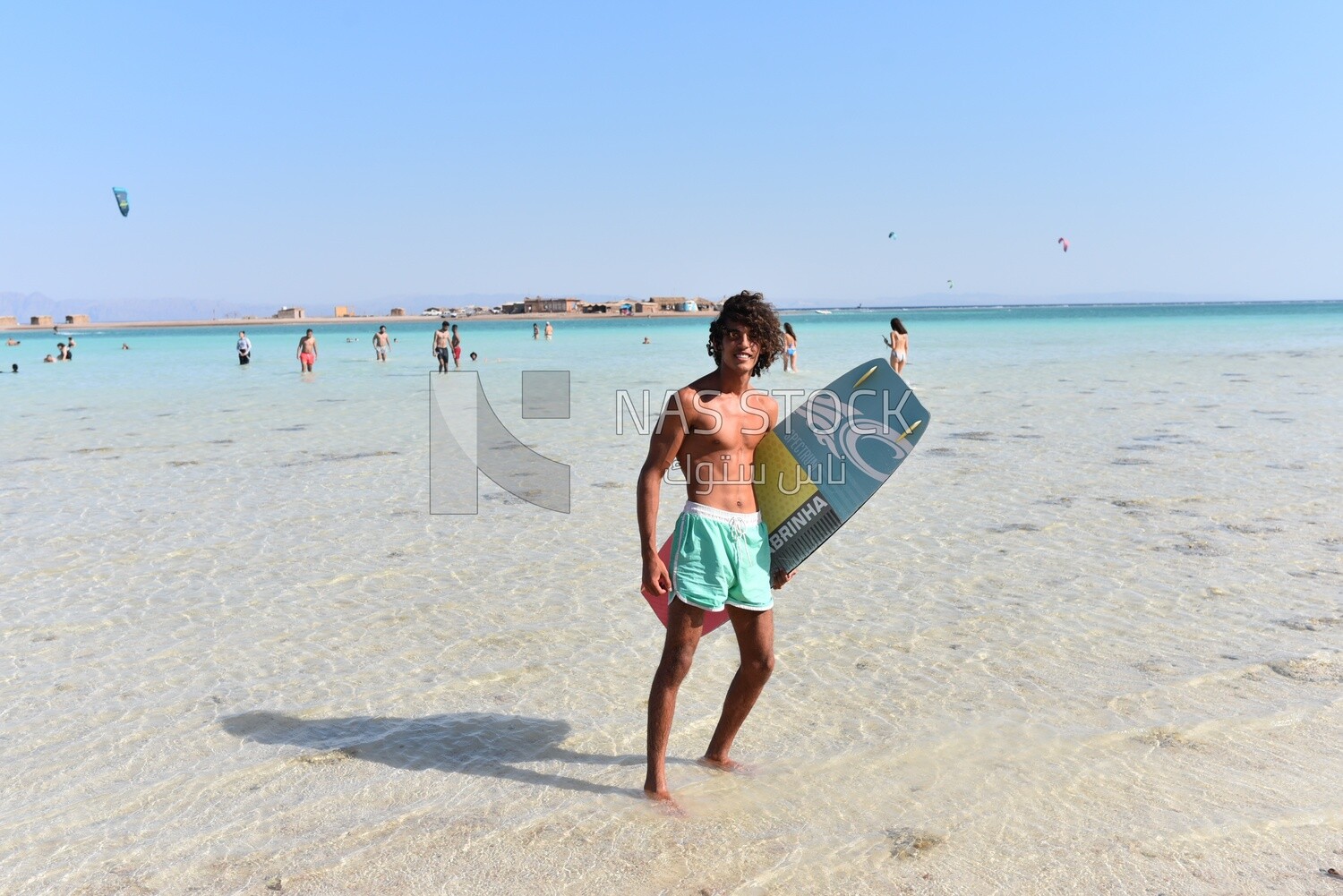 Young man in a swimsuit holding a surfboard