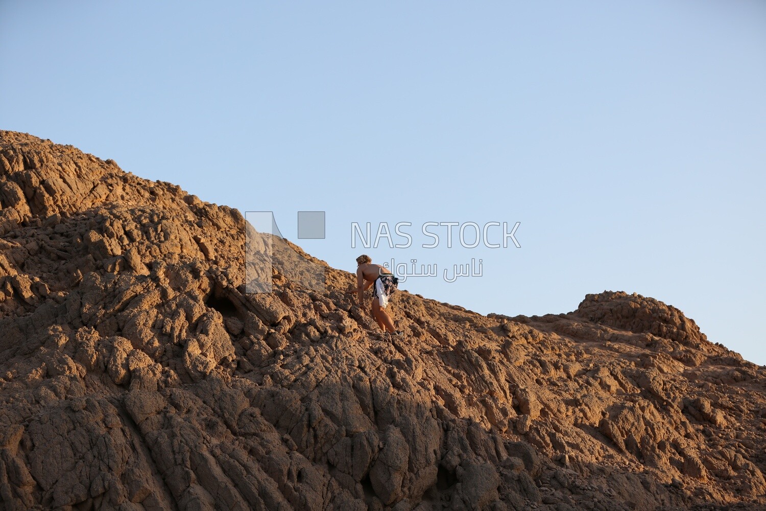 Adventurer climbing a hill in the Sinai Peninsula, Egypt