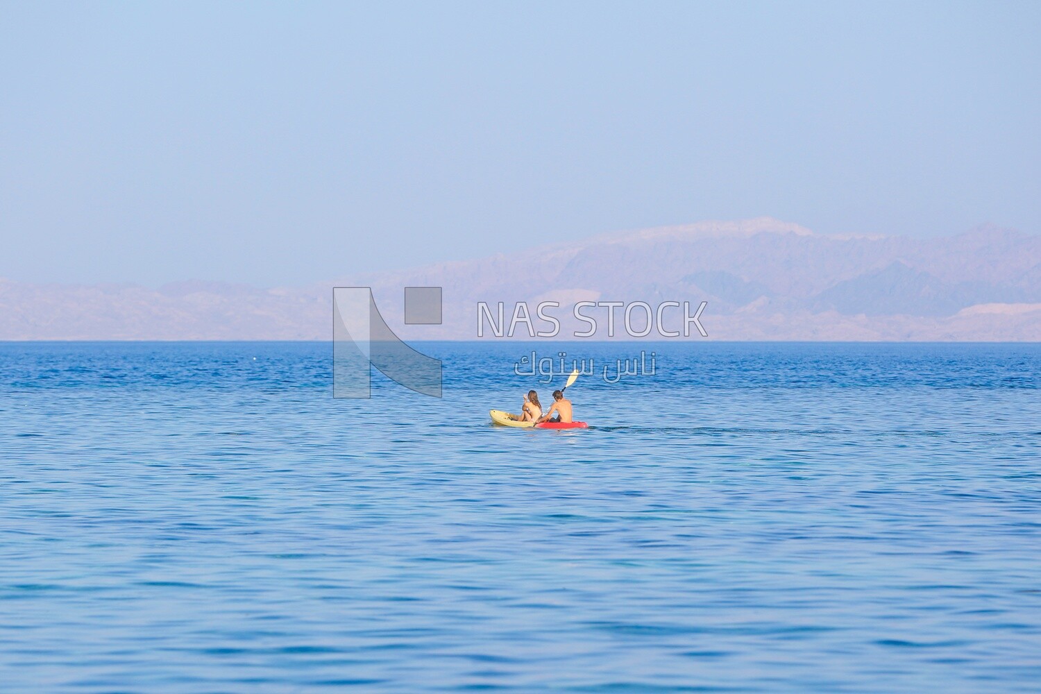 Couple enjoying paddling on a kayak in the sea , Egypt