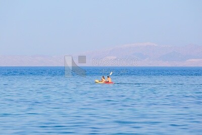 Couple enjoying paddling on a kayak in the sea , Egypt