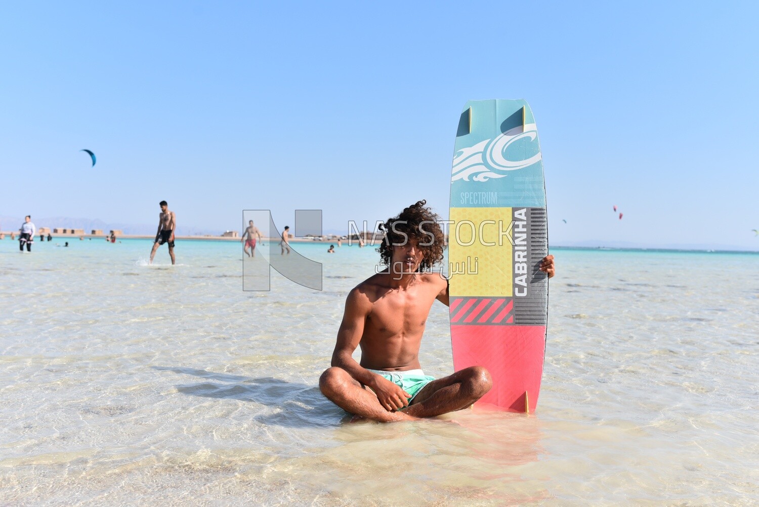 Young man in a swimsuit holding a surfboard