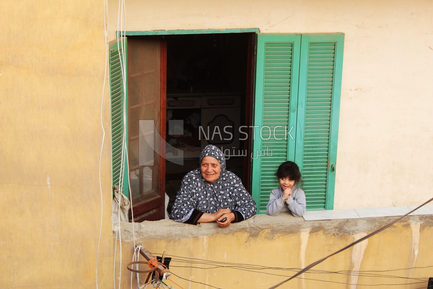 Women standing on the balcony watching the preparing of the iftar, Ramadan Kareem, preparing their iftar