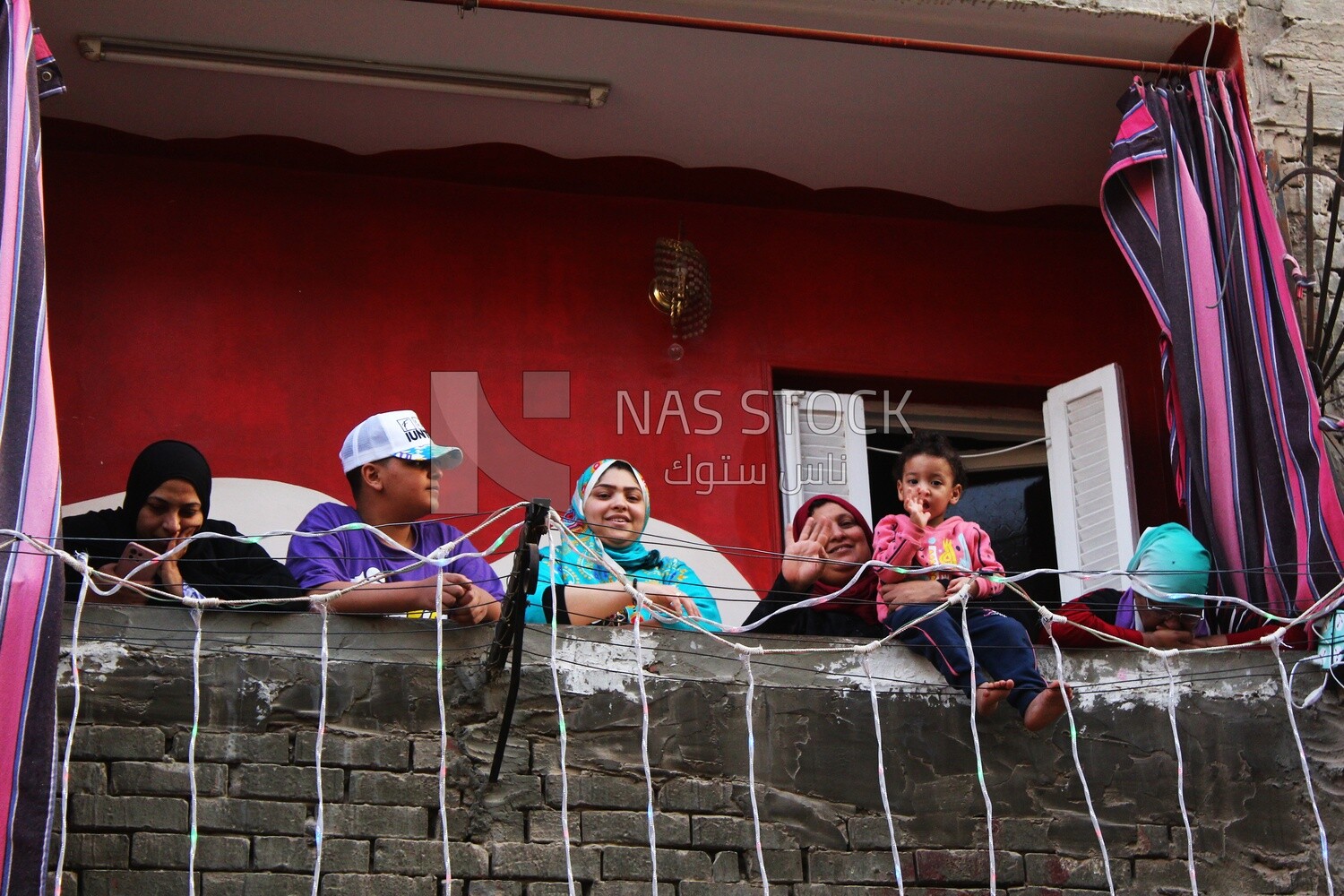 Family standing on the balcony watching the preparing of the iftar, Ramadan Kareem, preparing their iftar