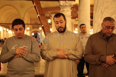 Worshipers praying in a mosque, performing the obligatory prayer in the mosque, worship and draw close to God