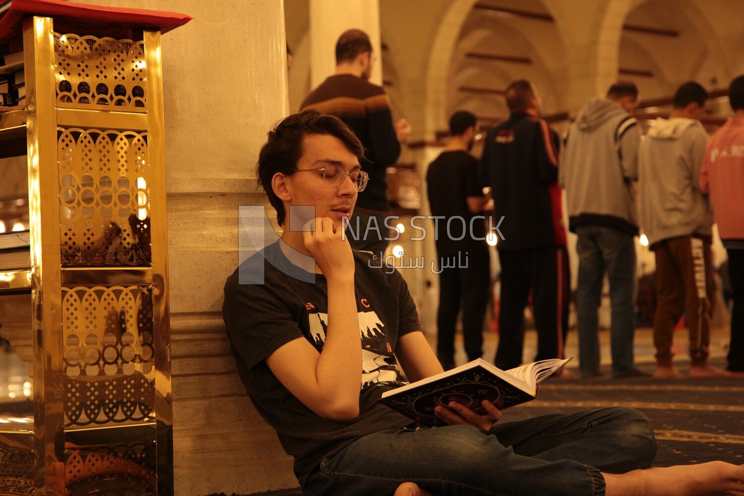 Man in the mosque reading the holy Quran, praying on the prayer rug, performing the obligatory prayer in the mosque, worship and draw close to God
