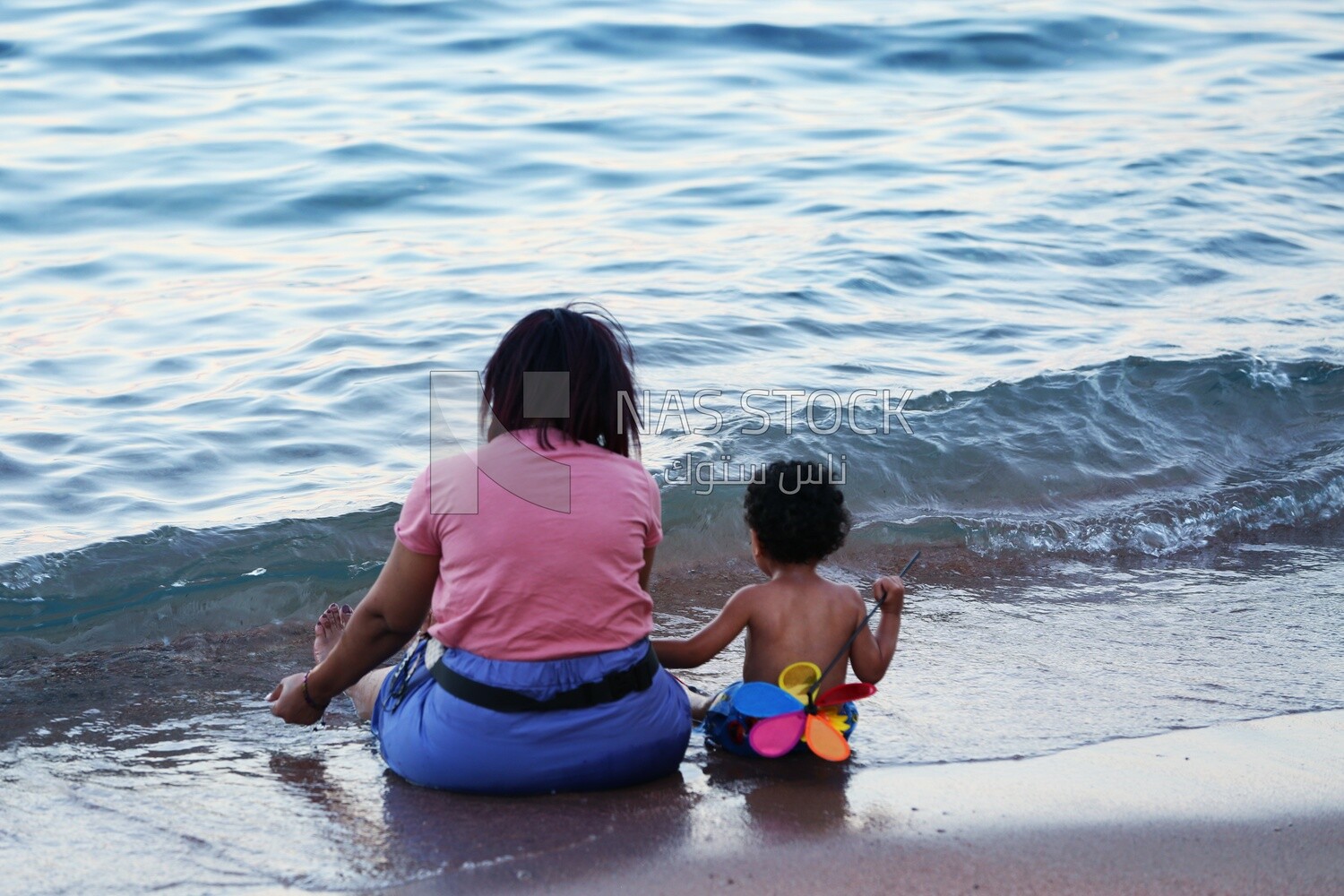 Mother with her child sitting on the sand