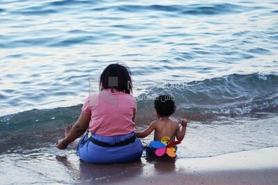 Mother with her child sitting on the sand