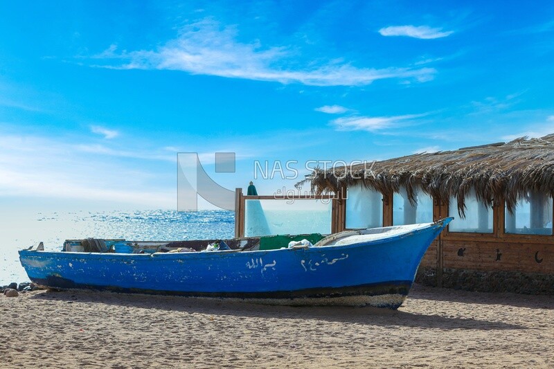 Wooden fishing boat anchored on the sand