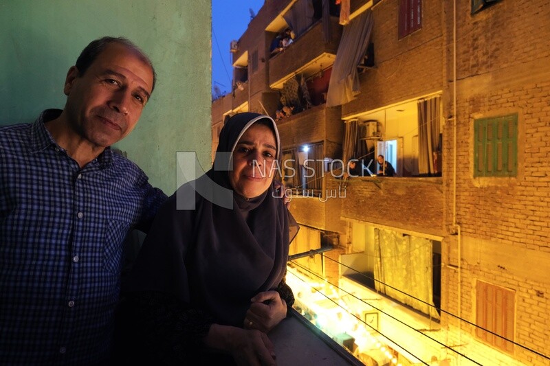 Family standing on the balcony watching the preparing of the iftar, Ramadan Kareem, preparing their iftar