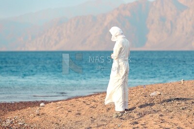 Man prays on the beach in front of the sea