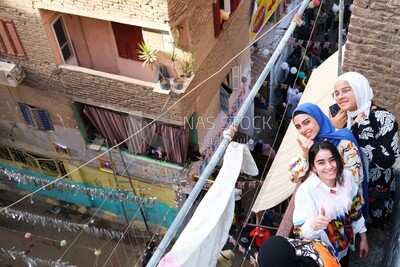 Women standing on the balcony watching the preparing of the iftar, Ramadan Kareem, preparing their iftar