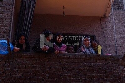 Women standing on the balcony watching the preparing of the iftar, Ramadan Kareem, preparing their iftar