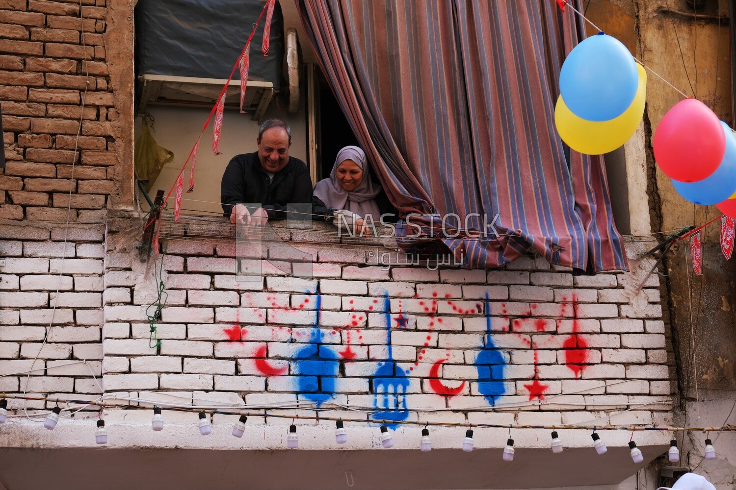 Family standing on the balcony watching the preparing of the iftar, Ramadan Kareem, preparing their iftar