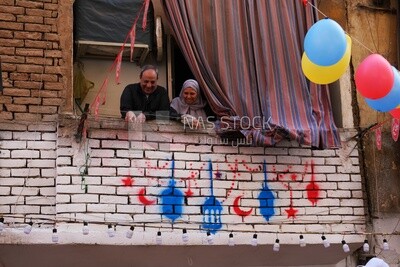 عائلة تقف في الشرفة يشاهدن تحضير الإفطار ، رمضان كريم ، يحضّرون الإفطار
