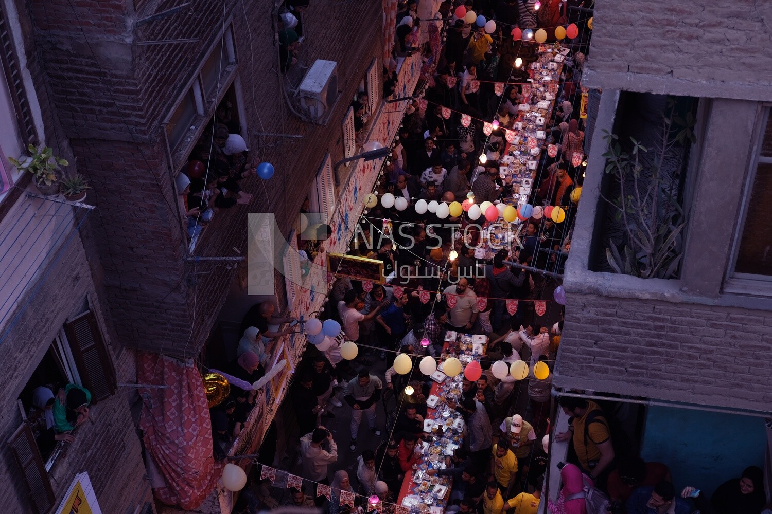 Top view of people in Matareya sharing their iftar together in the street, Ramadan Kareem, preparing their iftar