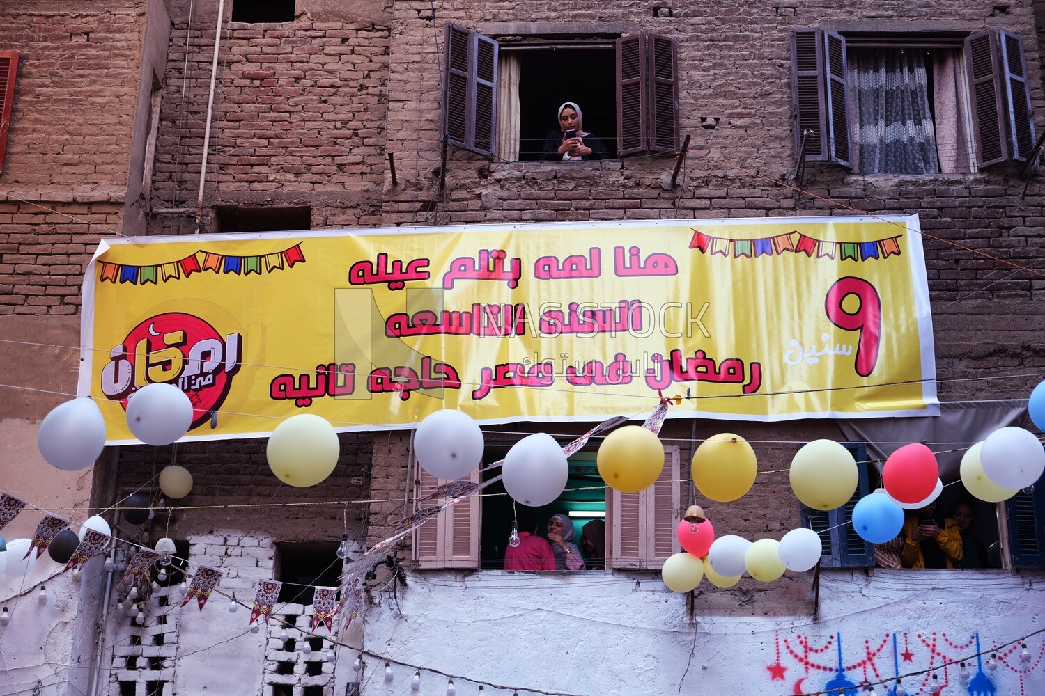 View of the sign hanging on the wall in the street at Matareya sharing their iftar together in the street, Ramadan Kareem, preparing their iftar