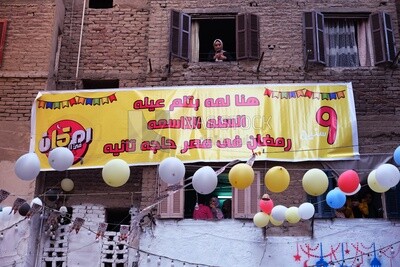 View of the sign hanging on the wall in the street at Matareya sharing their iftar together in the street, Ramadan Kareem, preparing their iftar