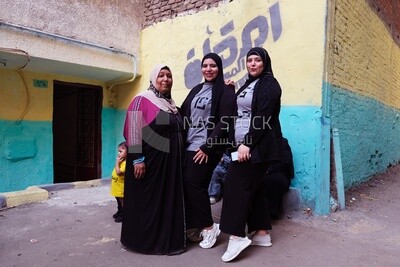 Women standing in the street taking a photo during the iftar on Matareya, Ramadan Kareem, preparing their iftar